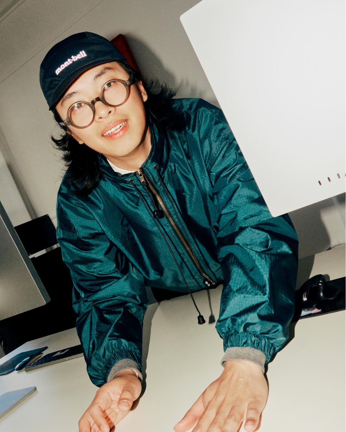 Designer leaning over his desk smiling